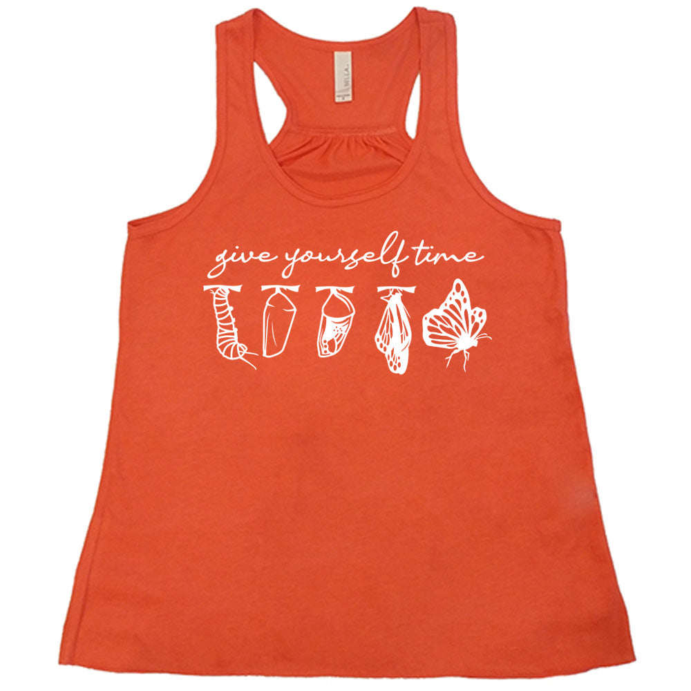coral flowy racerback tank with the graphic of the complete metamorphosis of a butterfly, with words above it saying "give yourself time"