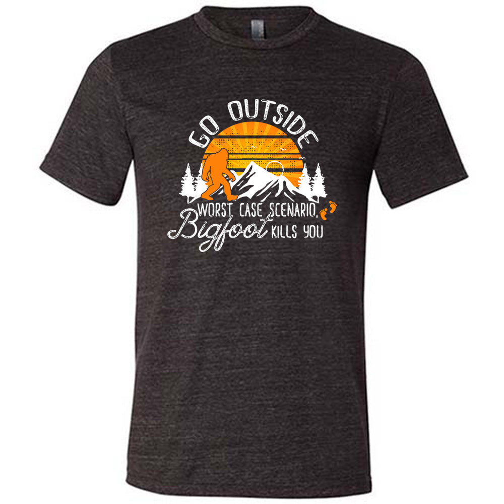 Black colored shirt with sun and bigfoot in mountains graphic on it that says "Go Outside, Worst Case Scenario Bigfoot Kills You"