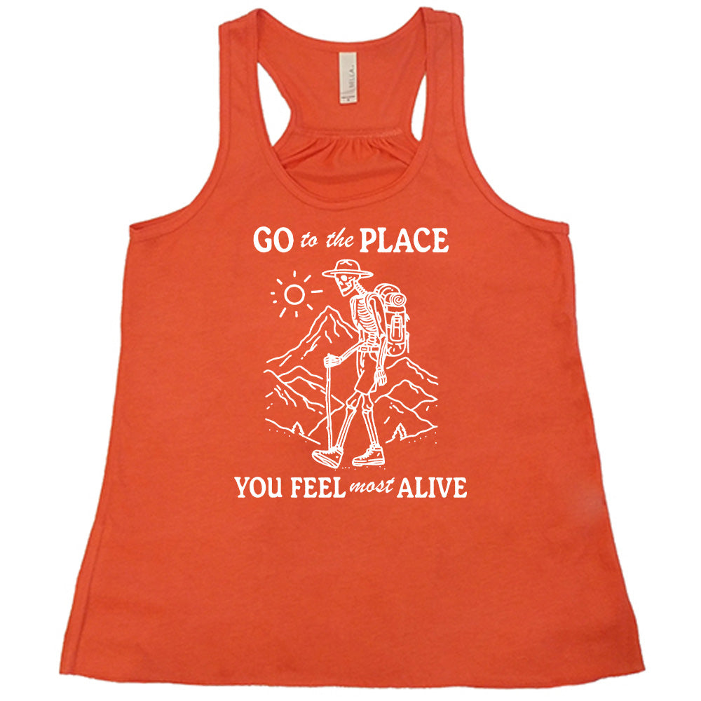 Coral colored flowy tank with a skeleton on a hike graphic on it that says "Go To The Place You Feel Most Alive" 