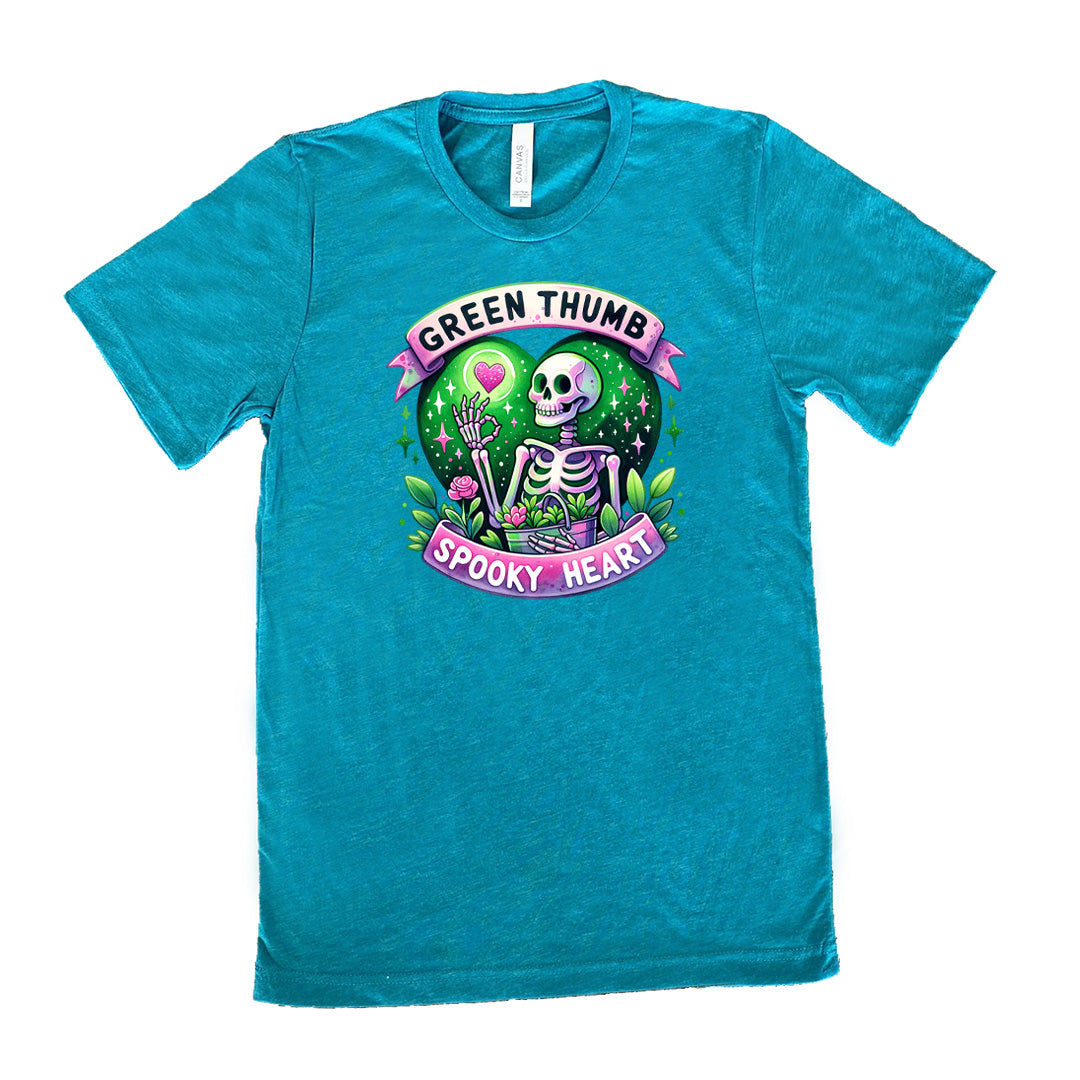 Teal colored shirt with a skeleton and plants graphic on it that says "Green Thumb Spooky Heart"