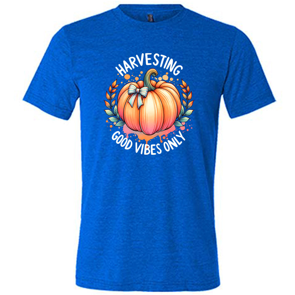 Blue colored shirt with pumpkin graphic on it that says "Harvesting Good Vibes Only"