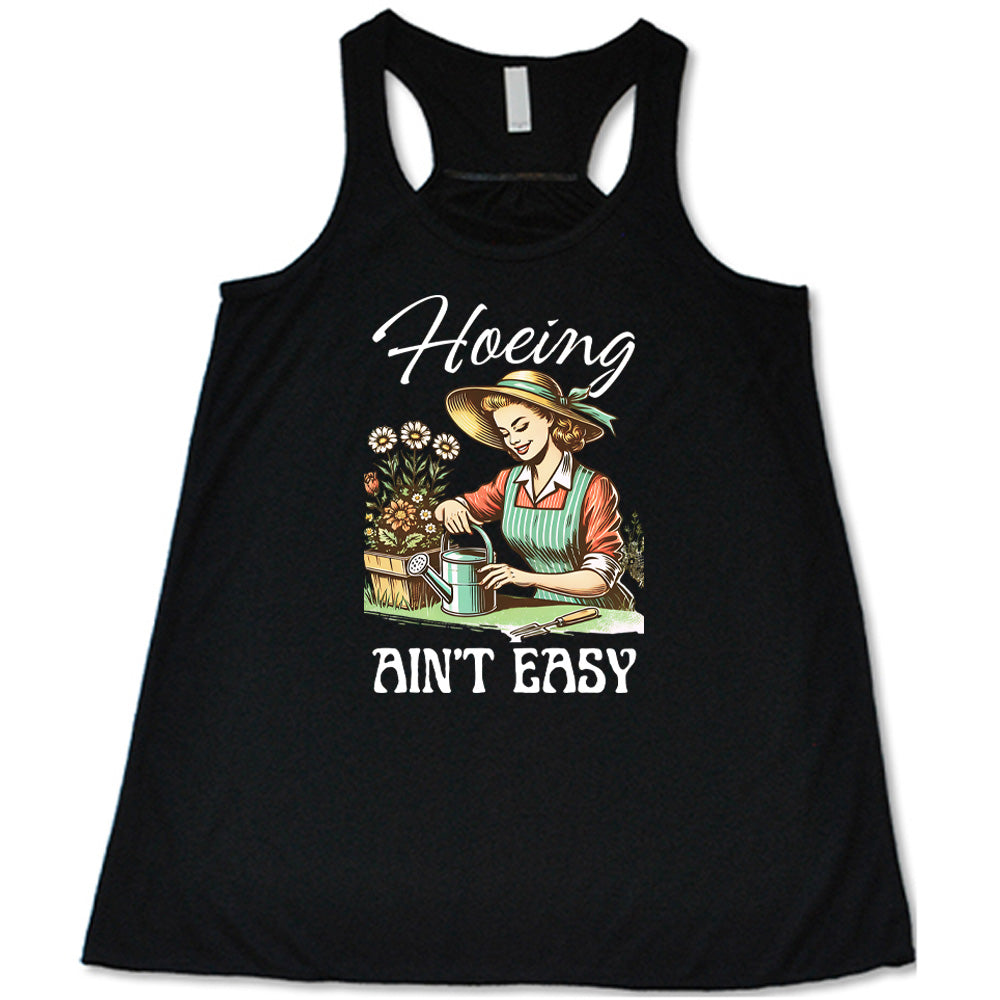 Black colored flowy tank with a woman gardening graphic on it that says "Hoeing Ain't Easy" 
