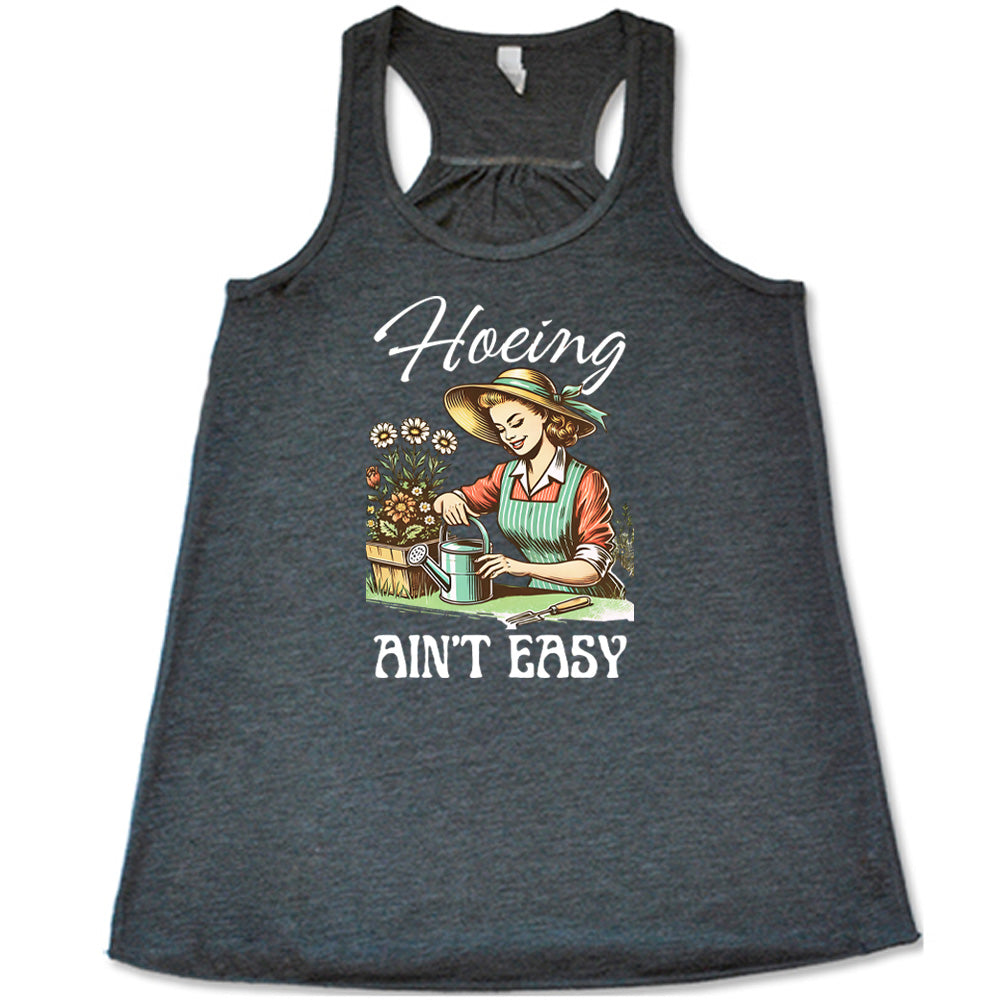 Grey colored flowy tank with a woman gardening graphic on it that says "Hoeing Ain't Easy" 