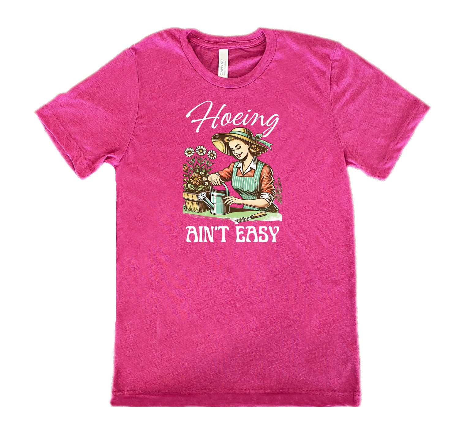 Berry colored shirt with a woman gardening graphic on it that says "Hoeing Ain't Easy"
