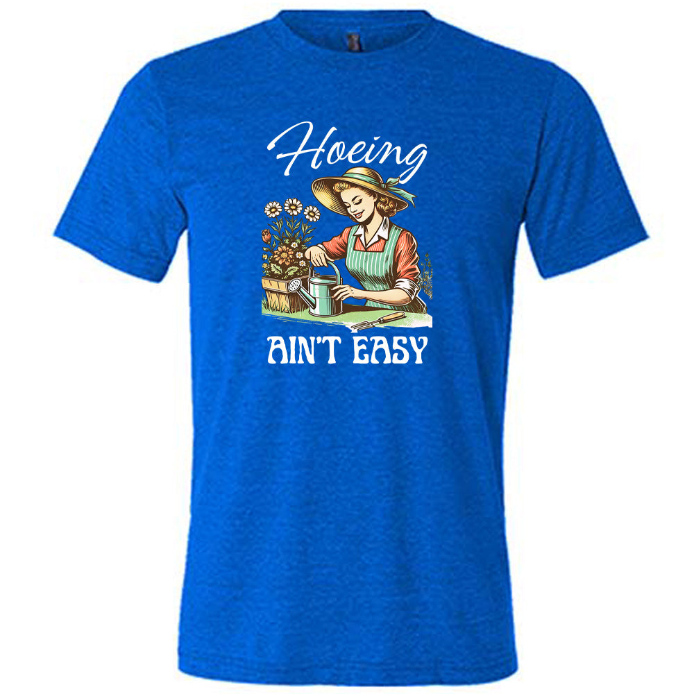 Blue colored shirt with a woman gardening graphic on it that says "Hoeing Ain't Easy"