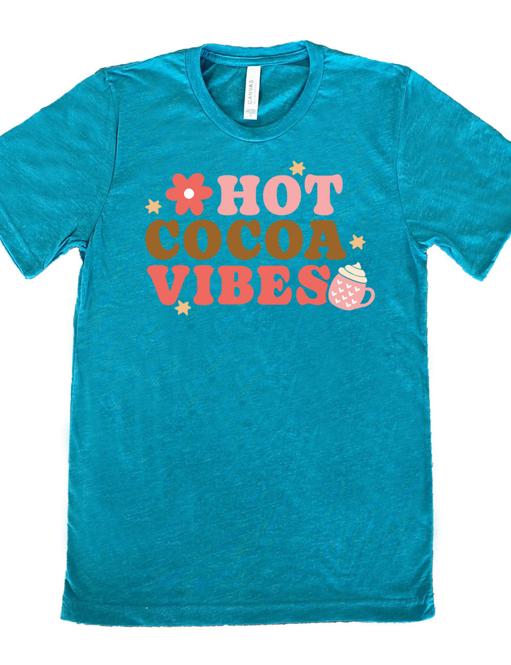 teal unisex tee with the colorful words saying "HOT COCOA VIBES" with small graphics of a flower and mug, with many hearts on it, topped with whipped cream, and a few stars
