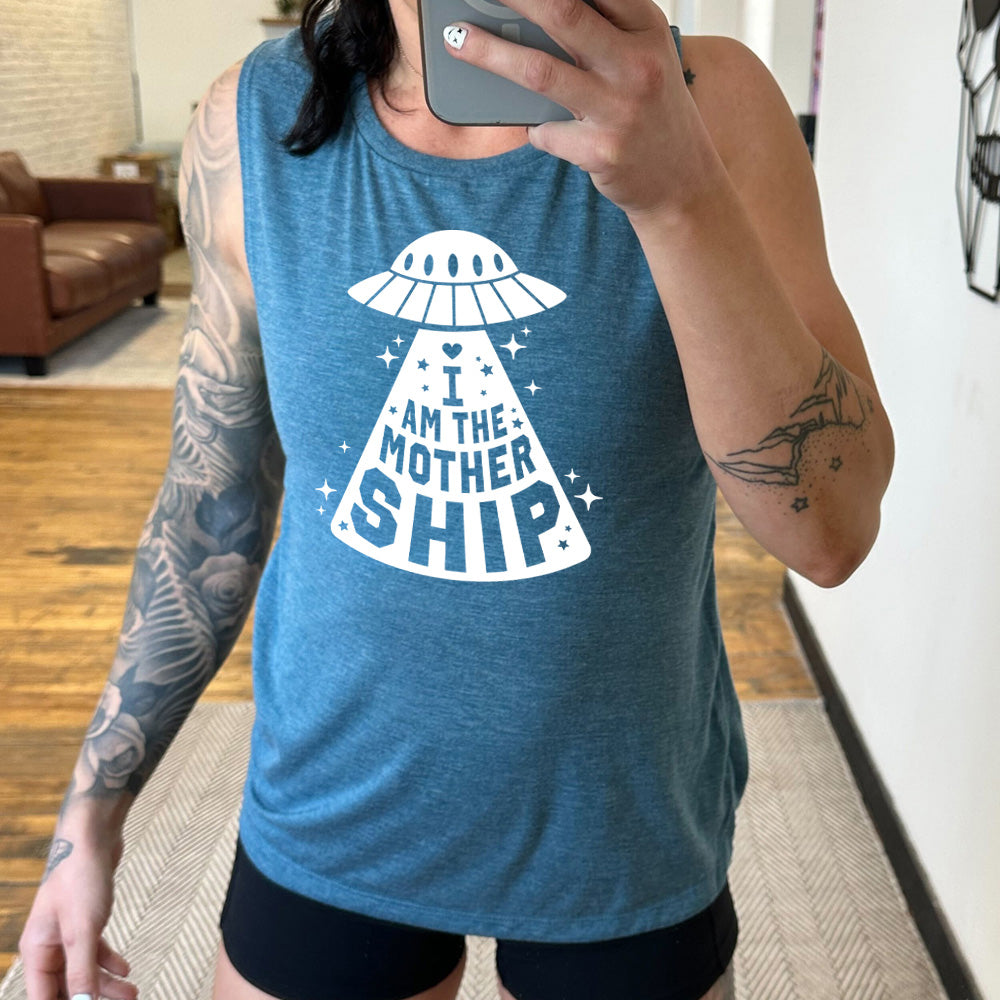 deep teal muscle tank with the words "I am the mothership" on it within the beam of a UFO, with a heart above the words, and a number of stars scattered around