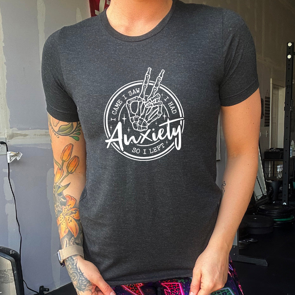 Black colored shirt with a skeleton peace sign graphic on it that says "I Came I Saw I Had Anxiety So I Left"