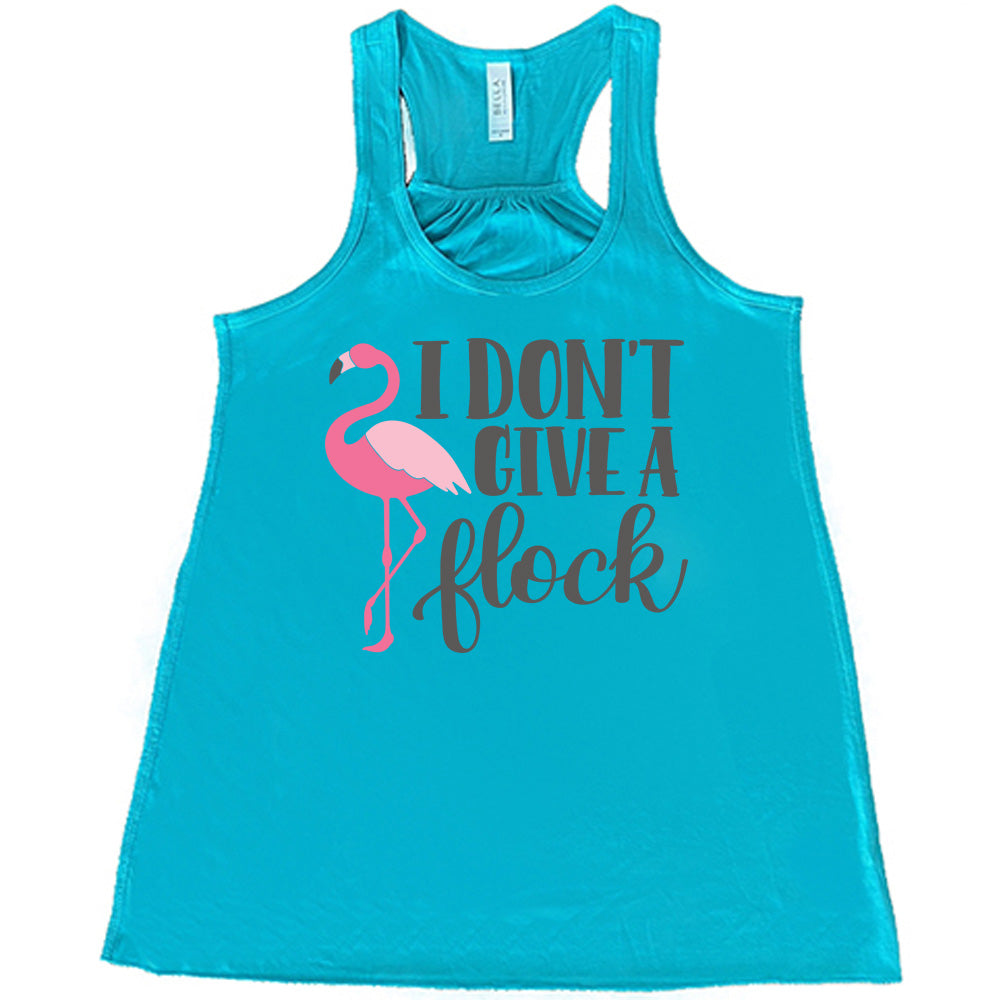 teal flowy racerback tank with the words "I don't give a flock" on it, with the graphic of a flamingo next to these words, leg raised