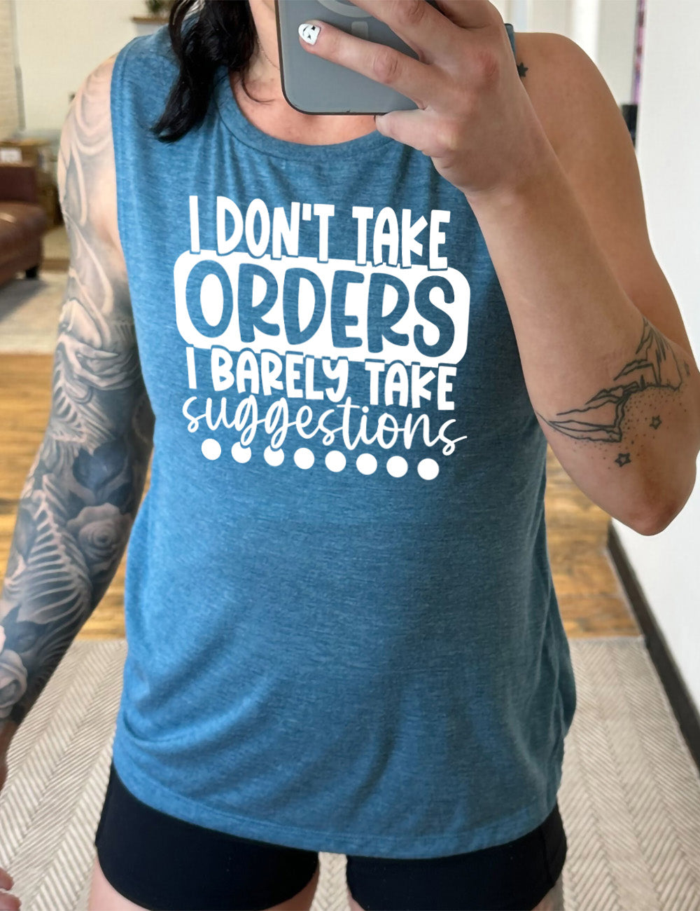 deep teal muscle tank with the words "I don't take orders I barely take suggestions" on it, with a row of dots underneath