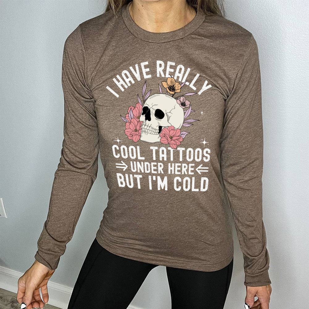 heather brown long sleeve with the words "I have really cool tattoos under here but I'm cold" with the image of a skull in flowers