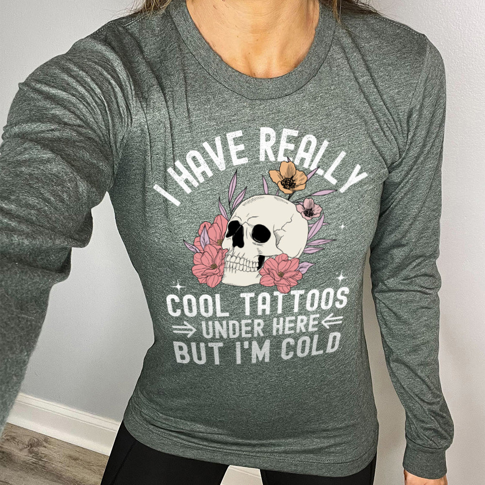heather forest long sleeve with the words "I have really cool tattoos under here but I'm cold" with the image of a skull in flowers