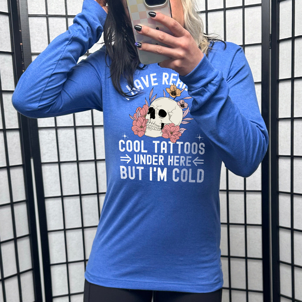 heather royal blue long sleeve with the words "I have really cool tattoos under here but I'm cold" with the image of a skull in flowers