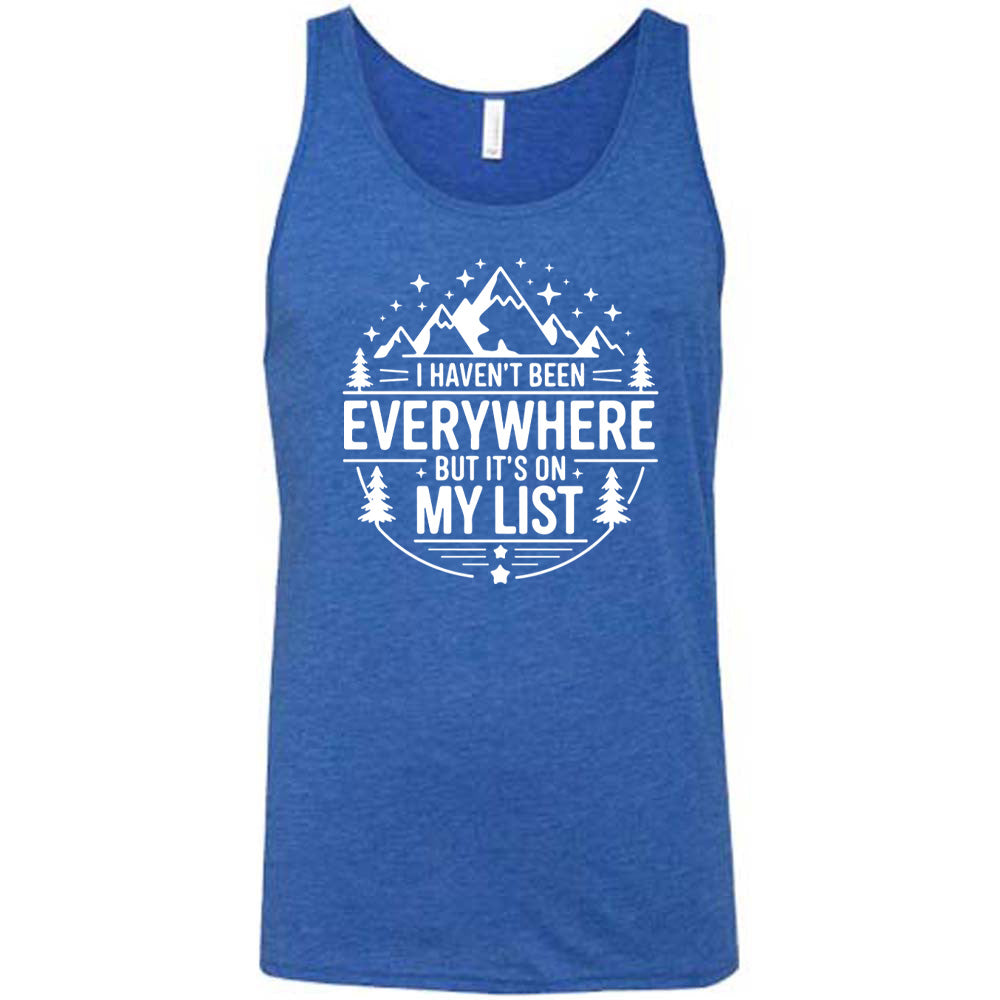 black unisex tank with the words "I haven't been everywhere but it's on my list" as part of a circular design involving the graphic of small mountains on top and a few trees on the sides and stars scattered around