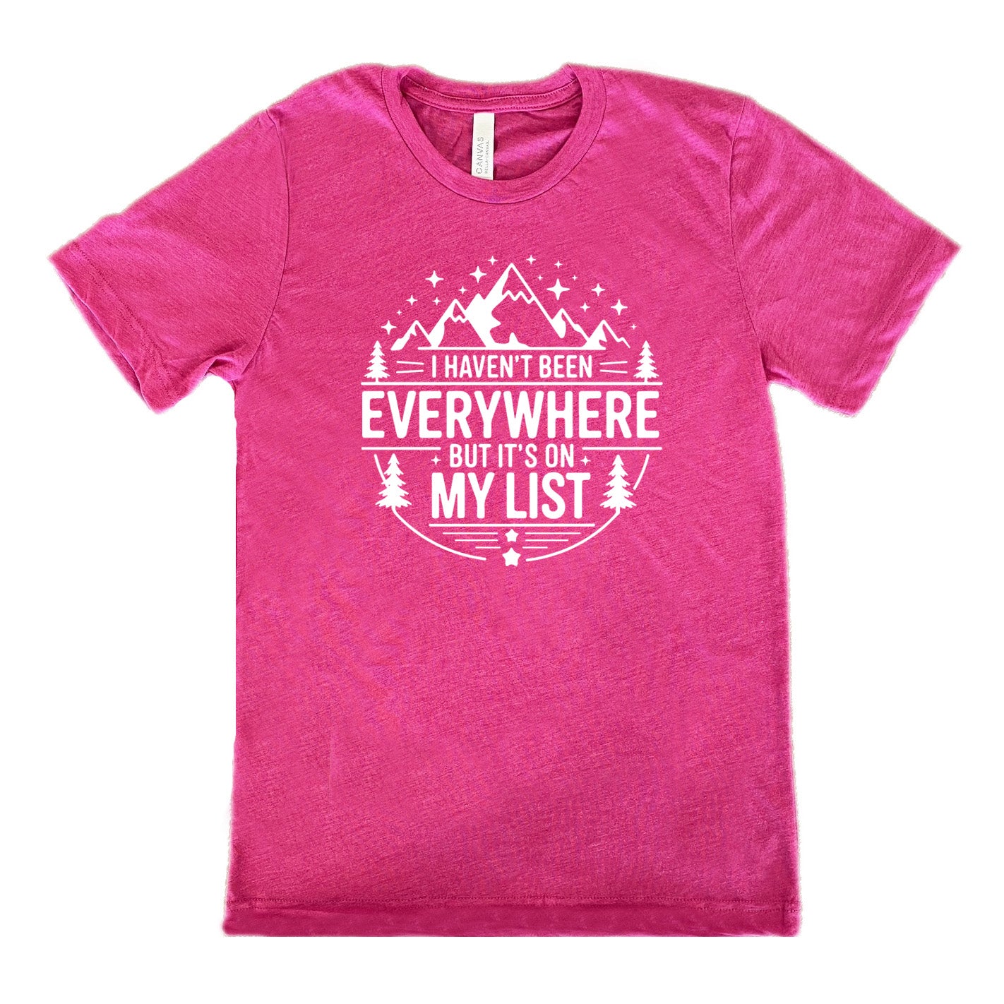 berry unisex tee with the words "I haven't been everywhere but it's on my list" as part of a circular design involving the graphic of small mountains on top and a few trees on the sides and stars scattered around