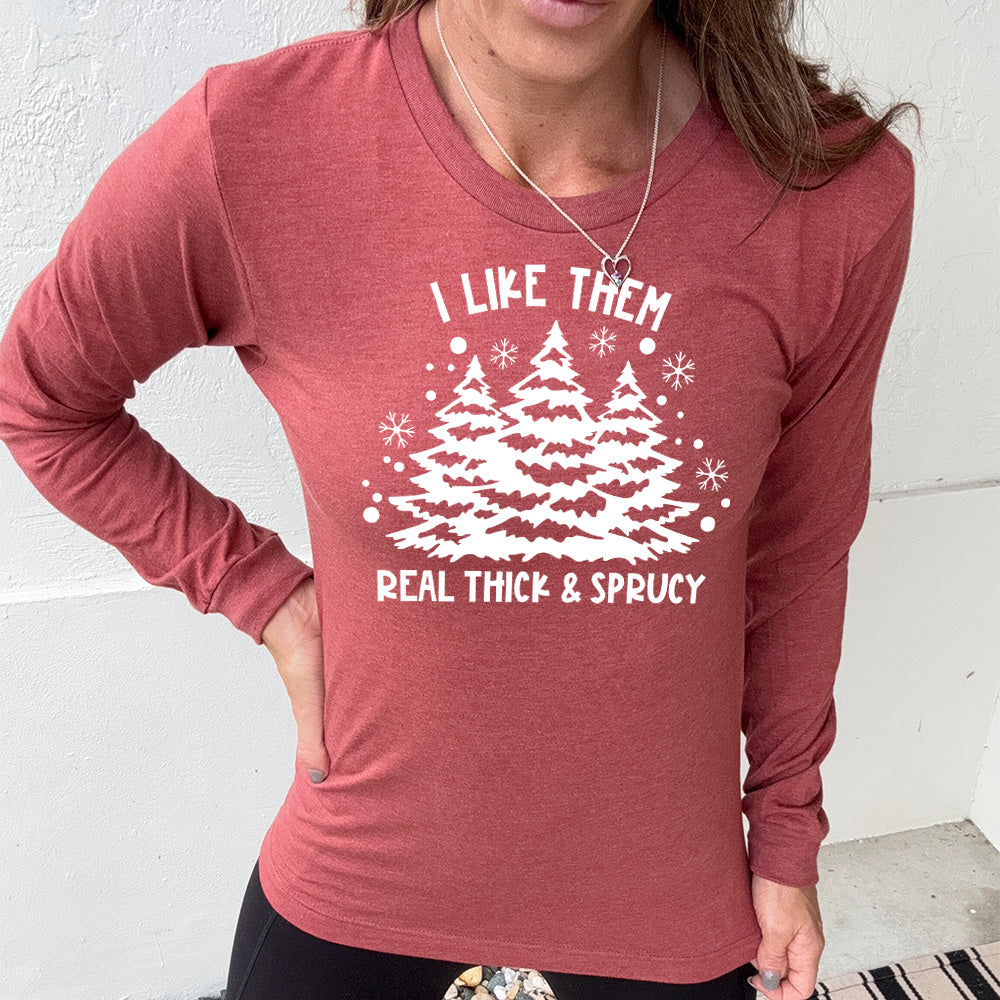 heather clay long sleeve with the words "I like them real thick & sprucy" and the graphics of big christmas trees and smaller snowflakes