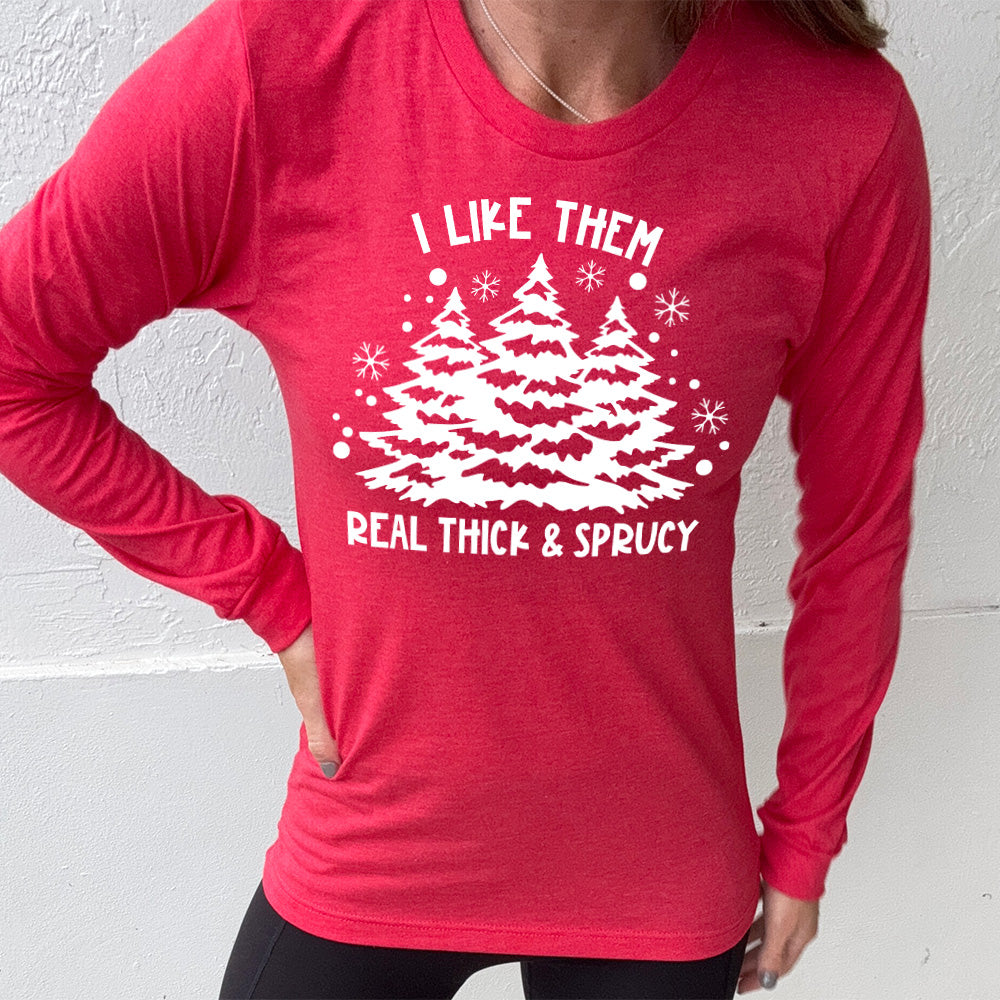 heather red long sleeve with the words "I like them real thick & sprucy" and the graphics of big christmas trees and smaller snowflakes
