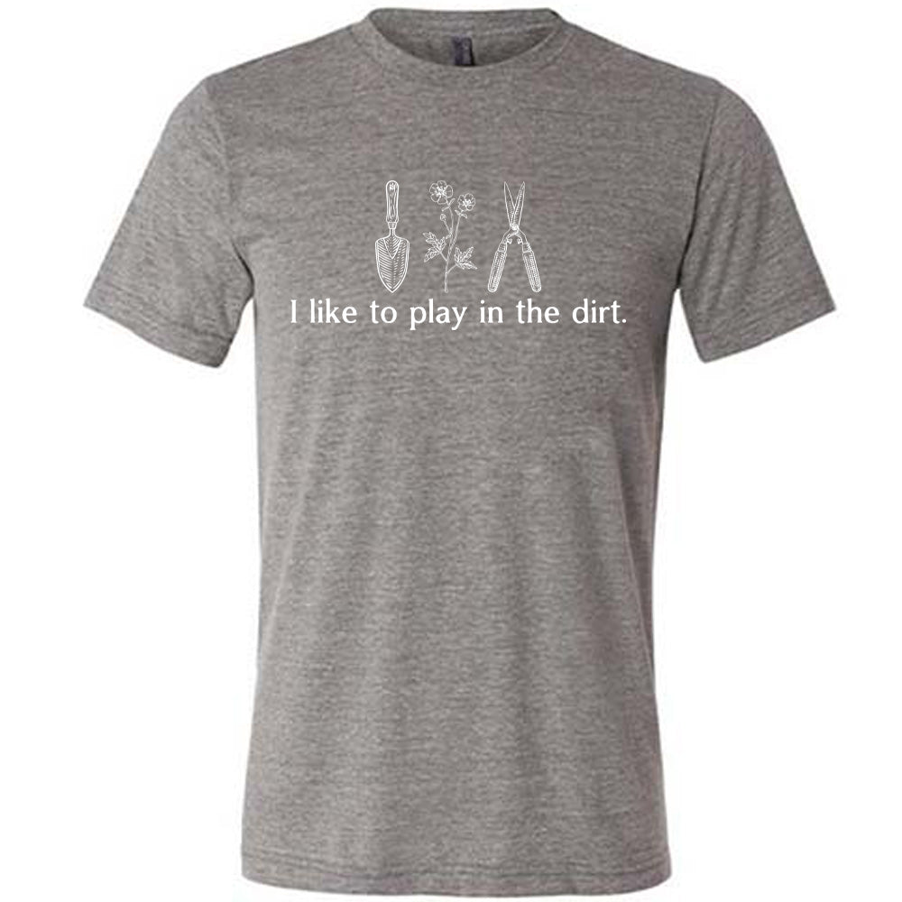 grey unisex tee with the words "I like to play in the dirt." on it with the graphic of a hand trowel, two flowers, and shears