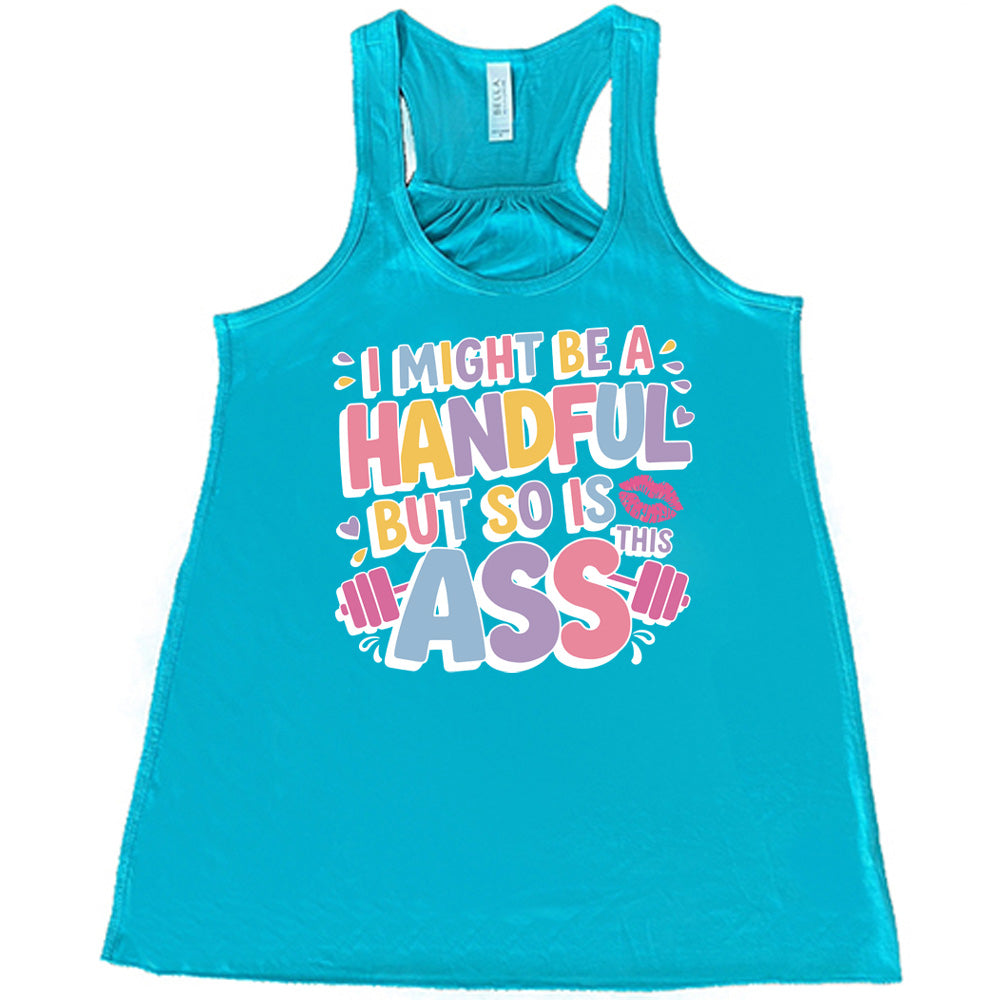 teal flowy tank with the words "I might be a handful but so is this ass" in a colorful font, with a barbell as part of the word "ass", and a few little hearts and a kissing lips graphic