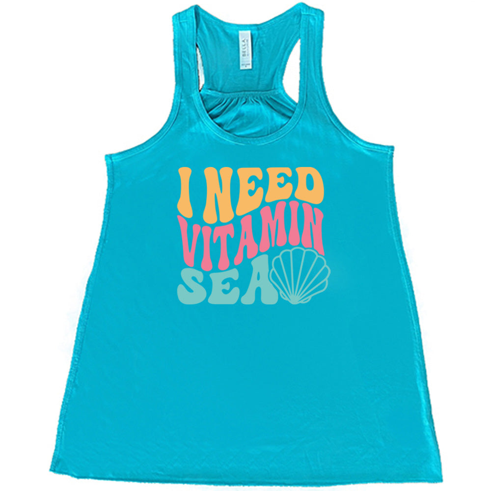 Teal colored flowy tank with a shell graphic on it that says "I Need Vitamin Sea" 