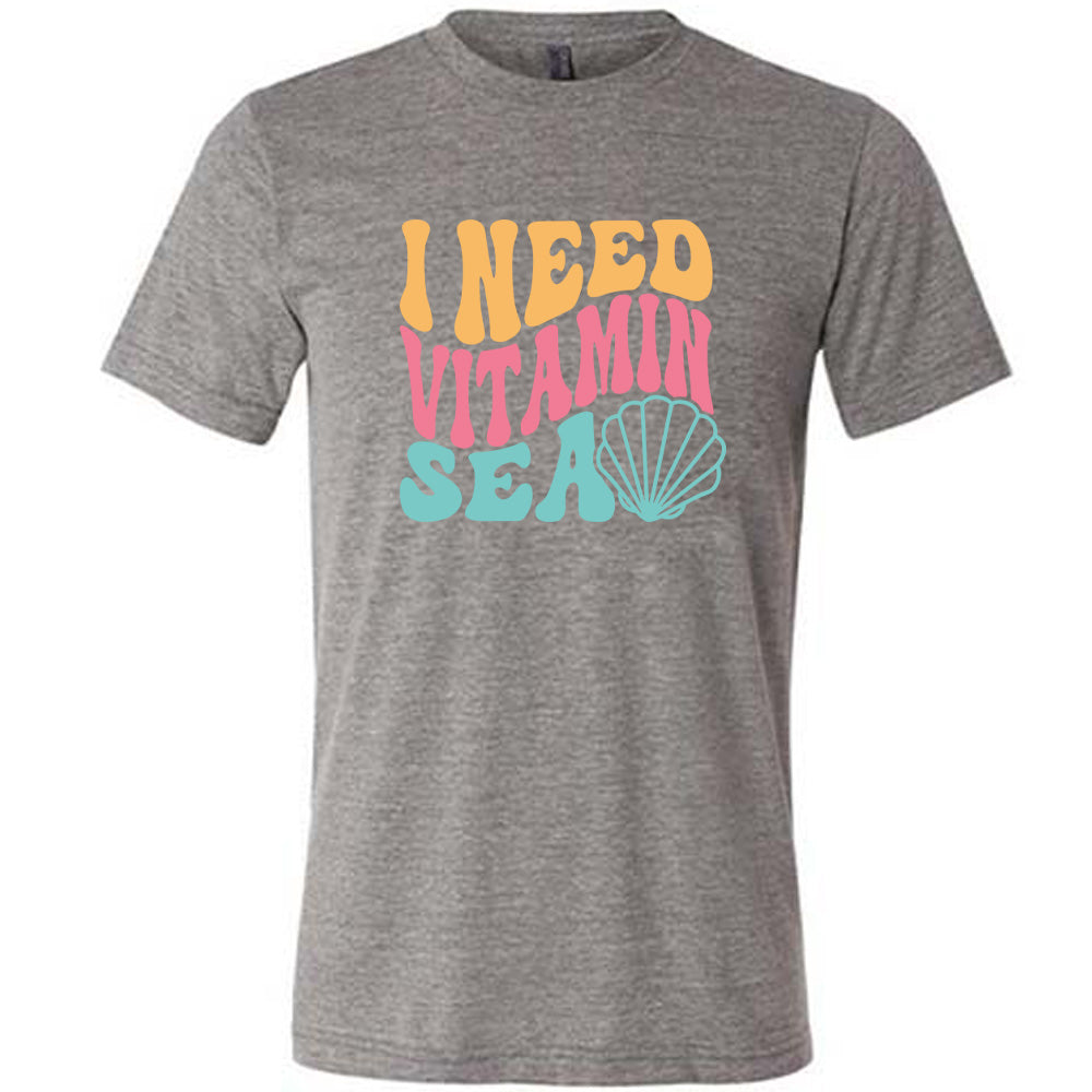 Grey colored shirt with a shell graphic on it that says "I Need Vitamin Sea" 