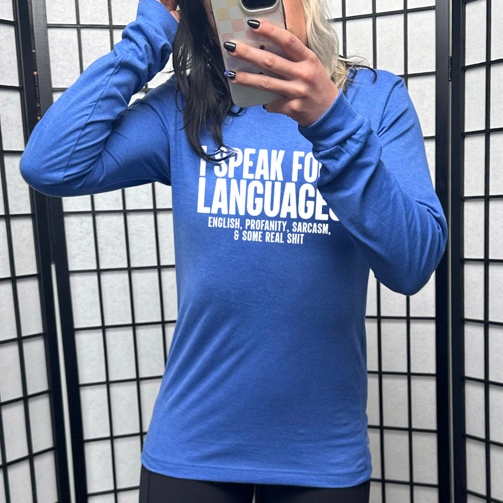 heather true royal long sleeve shirt with the words "I speak four languages" in big letters, and smaller words underneath saying "English, profanity, sarcasm, & some real shit"