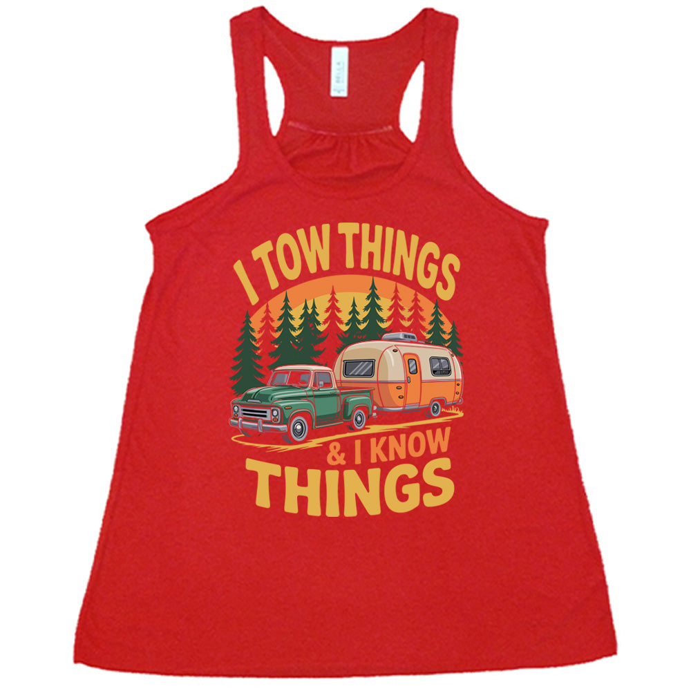 red flowy tank with the words "I tow things & I know thing" on it, with the graphic of an old-fashioned truck pulling a camper on a road lined with tall trees