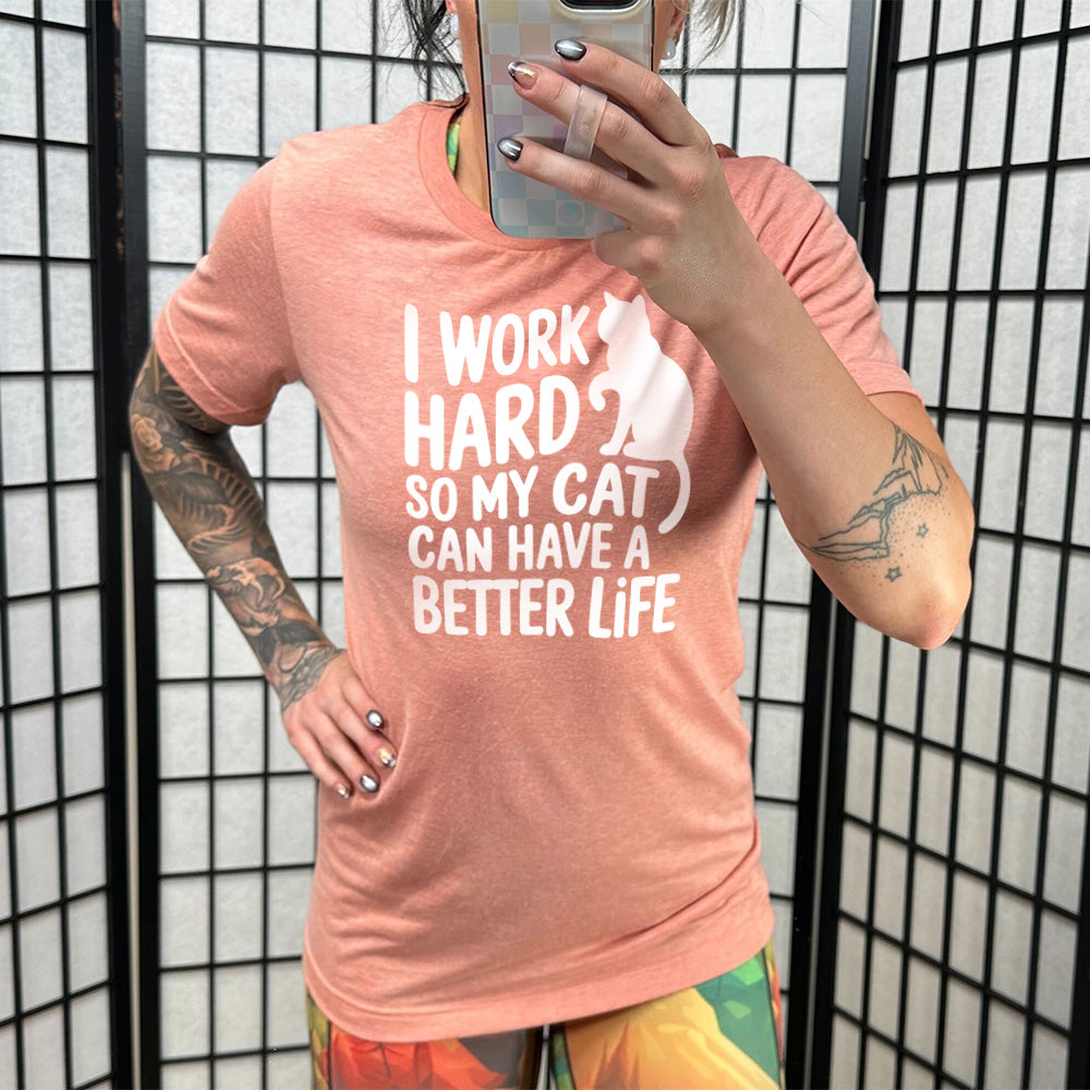 Model wearing sunset colored shirt with cat silhouette graphic on it that says "I Work Hard So My Cat Can Have A Better Life"