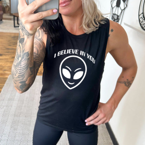 black muscle tank top with a "I believe in you" quote and alien head design on it