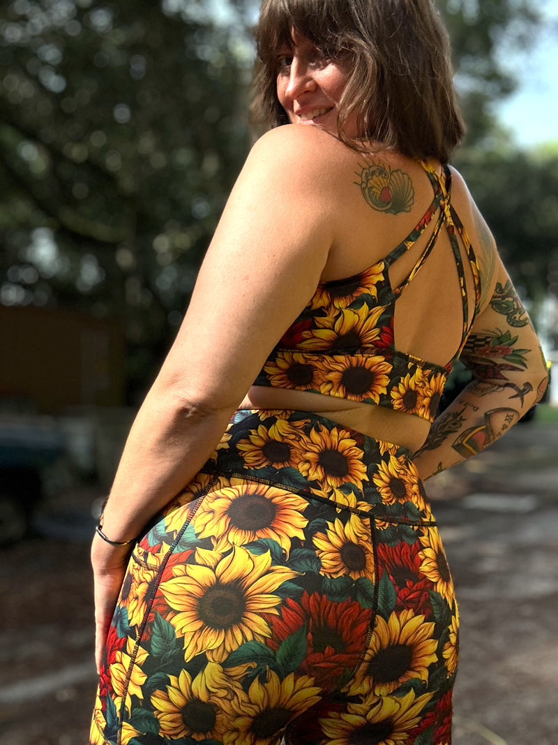 A woman wearing a matching two-piece sunflower print outfit