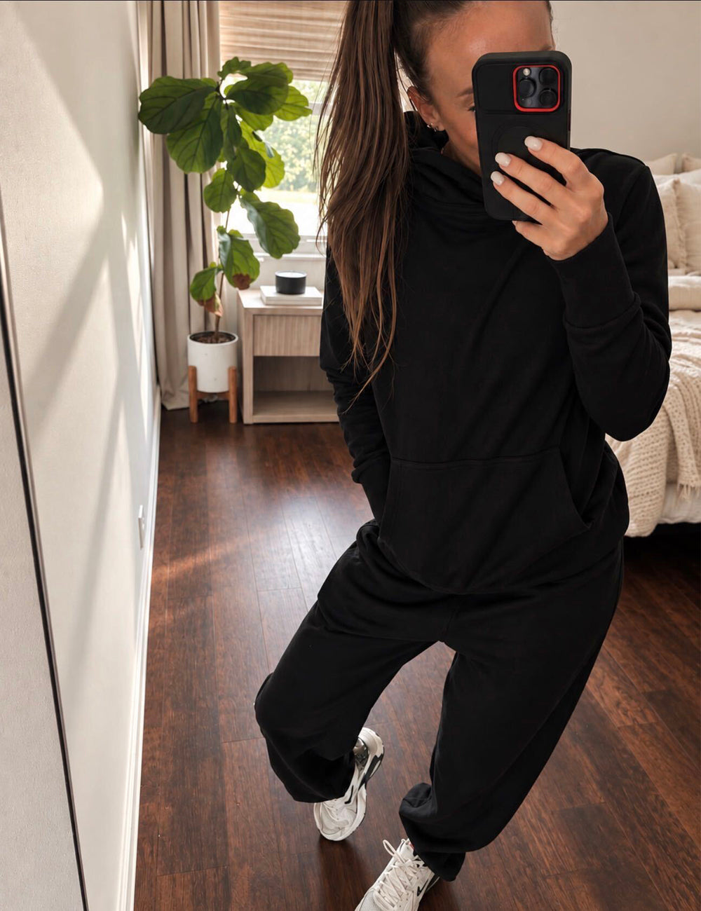 mirror selfie of model wearing black sweatpants and black sweatshirt