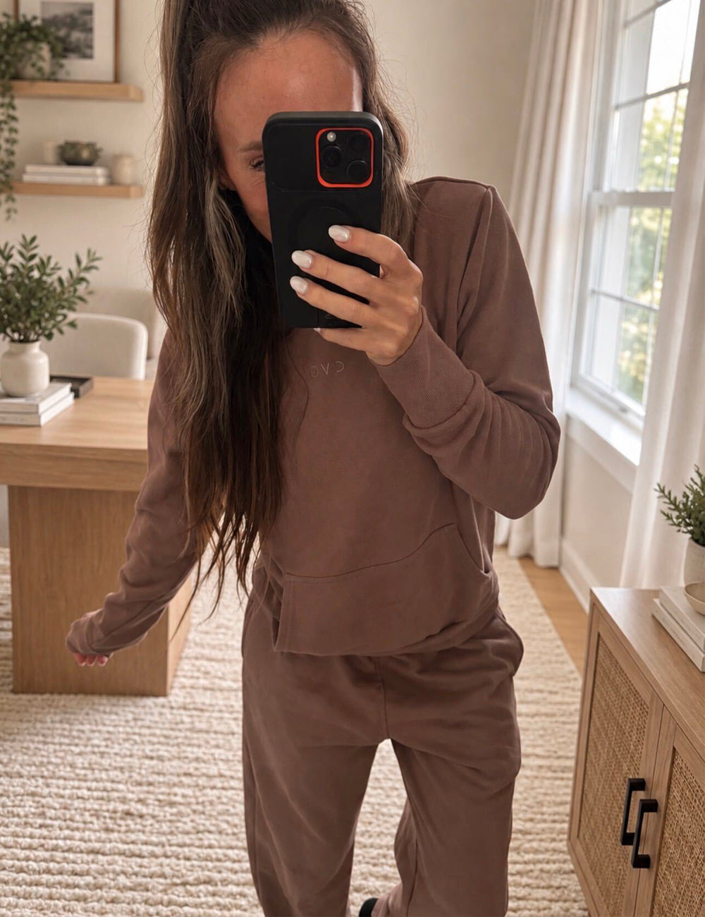 mirror selfie of a model wearing a brown sweatshirt and matching sweatpants