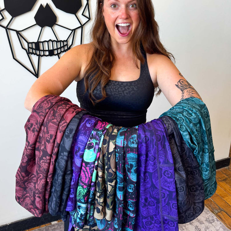 Woman holding colorful skull patterned leggings 