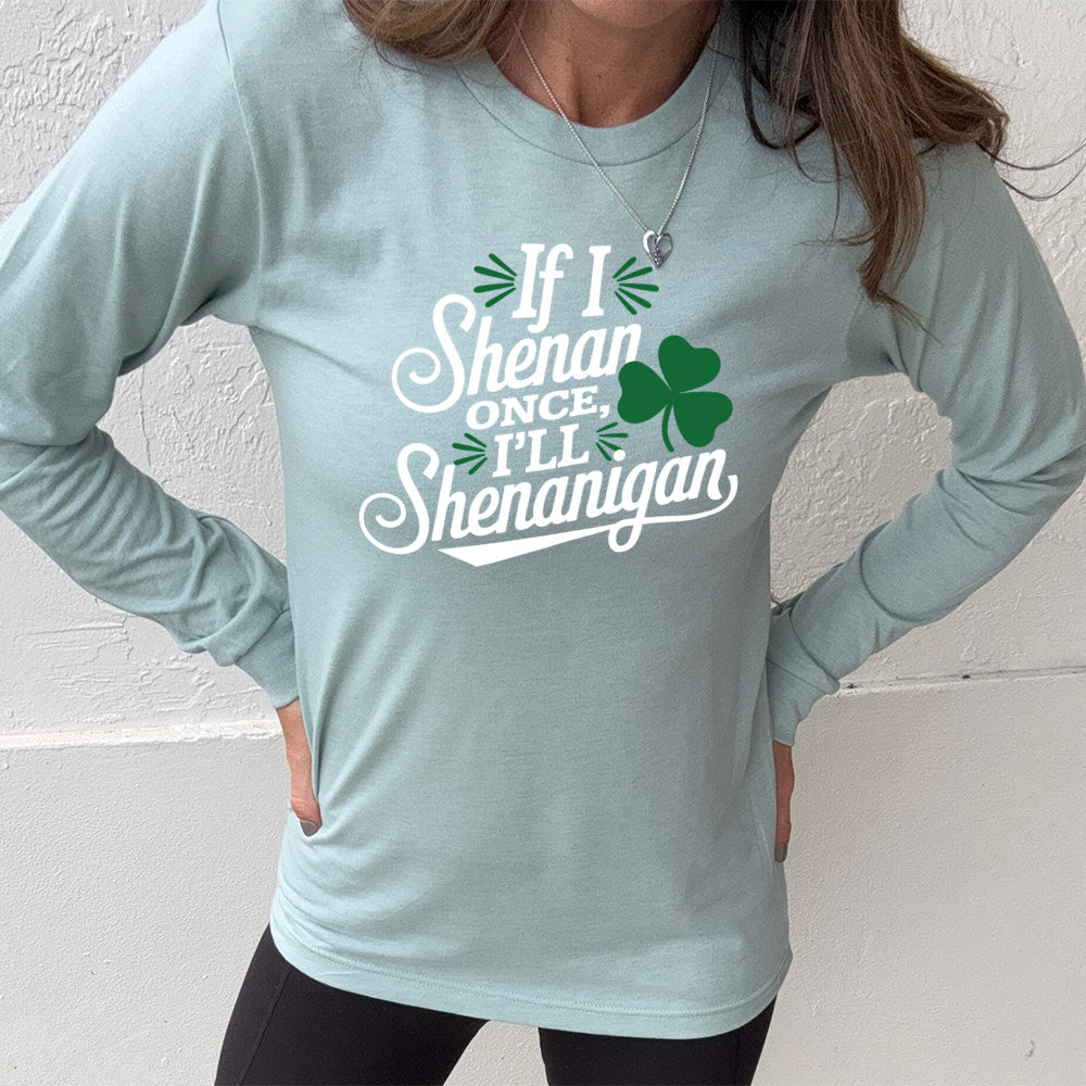 heather dusty blue long sleeve with the words "if I shenan once, I'll shenanigan" on it, with the graphic of a shamrock