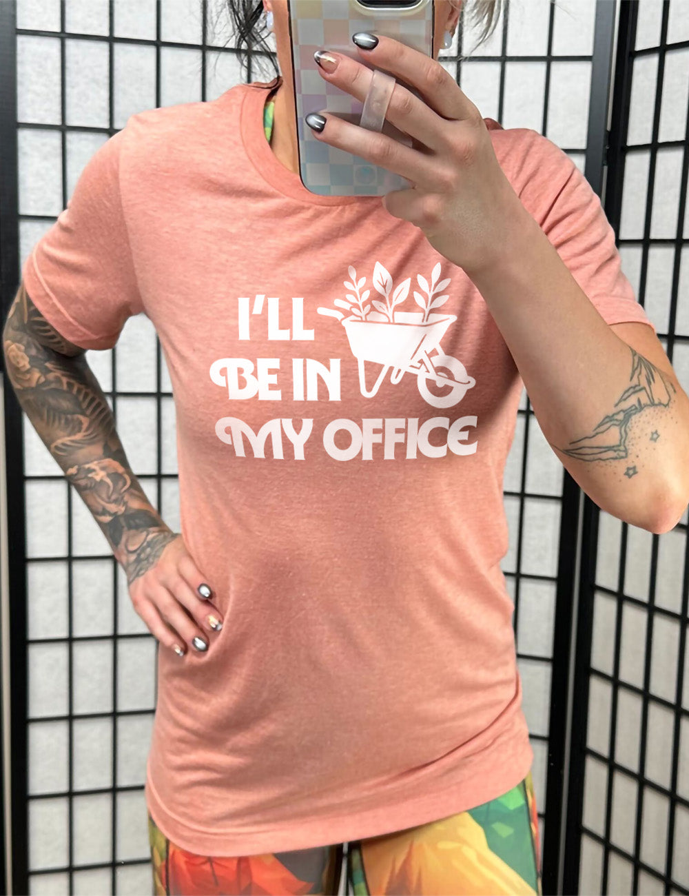 sunset unisex tee with the words "I'll be in my office" next to the  graphic of a wheelbarrow, with three plants sticking out of it