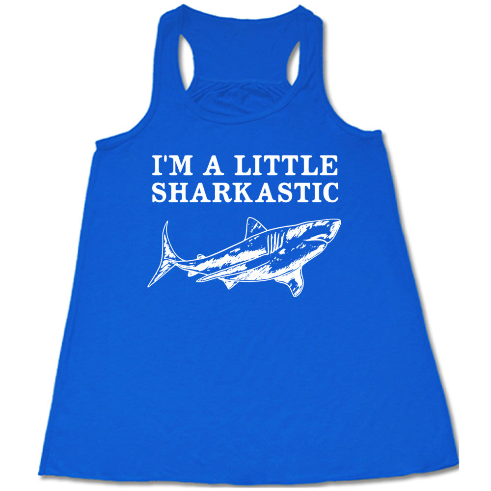 blue racerback flowy tank with the words "I'm a little sharkastic" on it, over the graphic of a shark