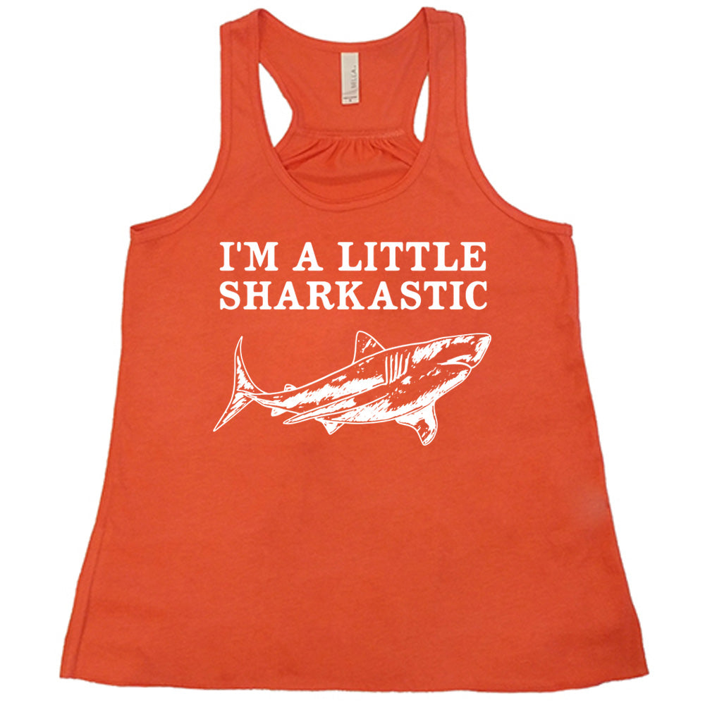 coral racerback flowy tank with the words "I'm a little sharkastic" on it, over the graphic of a shark