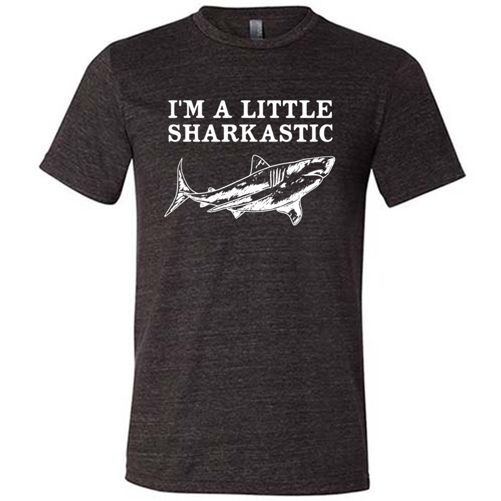 black unisex tee with the words "I'm a little sharkastic" on it, over the graphic of a shark