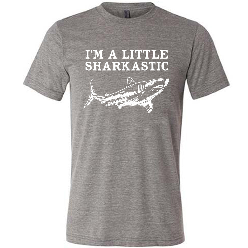 grey unisex tee with the words "I'm a little sharkastic" on it, over the graphic of a shark