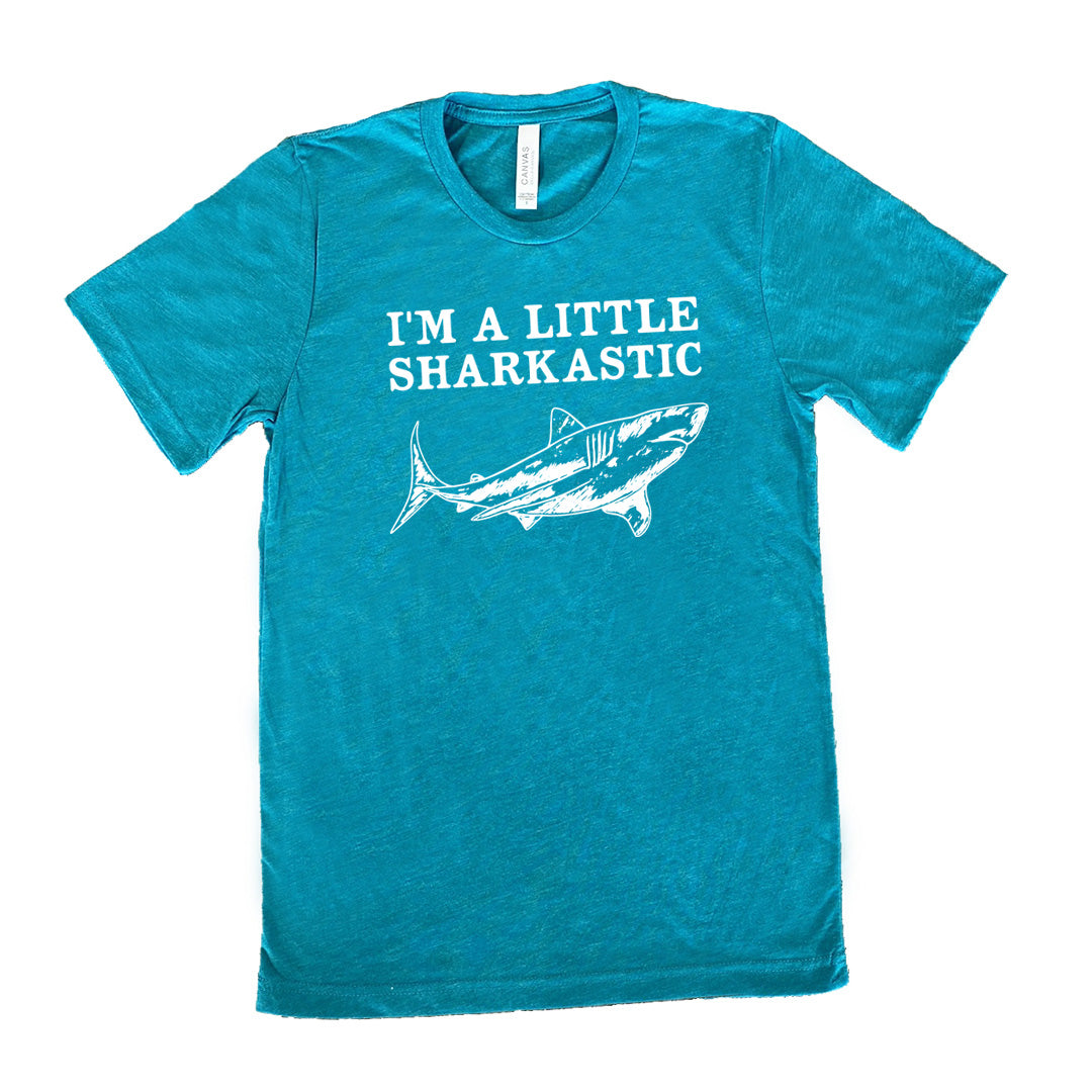 teal unisex tee with the words "I'm a little sharkastic" on it, over the graphic of a shark