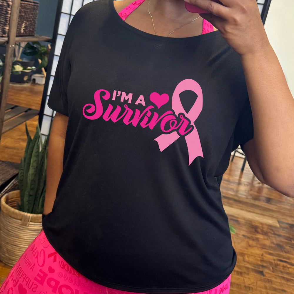 Person wearing a black t-shirt with 'I'm a Survivor' text and a pink ribbon design on it