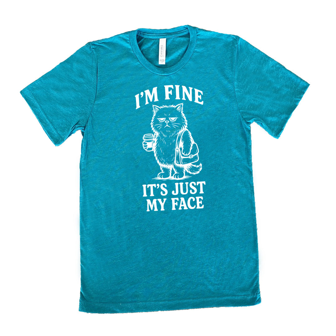 teal unisex tee with the words "I'm fine it's just my face" on it, around the graphic of a cat with a resting-grumpy face, holding a coffee and wearing a purse