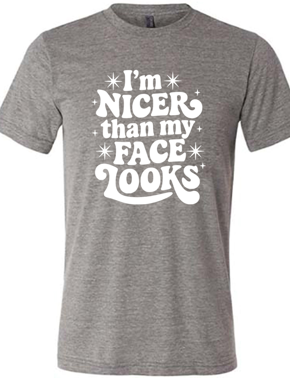 grey unisex tee with the words "I'm nicer than my face looks" surrounded by stars