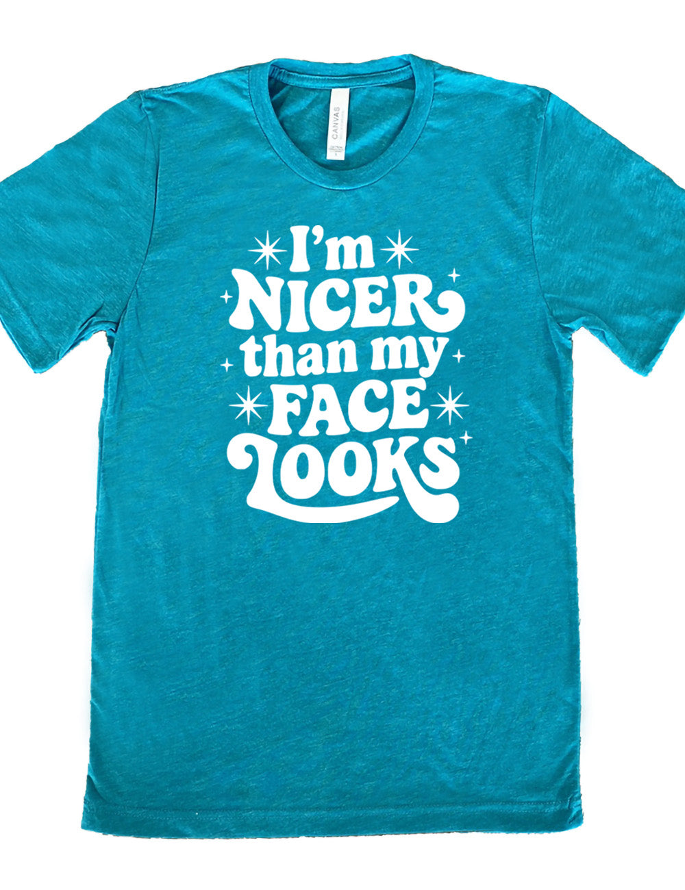 teal unisex tee with the words "I'm nicer than my face looks" surrounded by stars