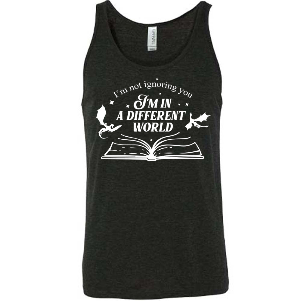 black unisex tank with the words "I'm not ignoring you I'm in a different world" on it, with the graphic of a large book, lying open, and two little dragons flying next to the words, a few stars scattered around