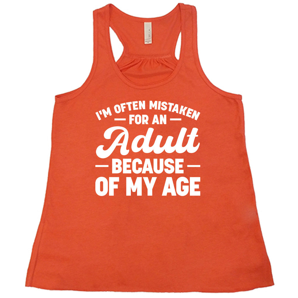 coral flowy tank with the words "I'm often mistaken for an adult because of my age" on it