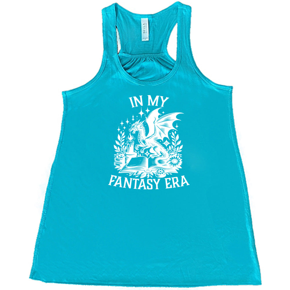 Teal colored flowy tank with a dragon lighting a candle over a book graphic on it that says "In My Fantasy Era" 