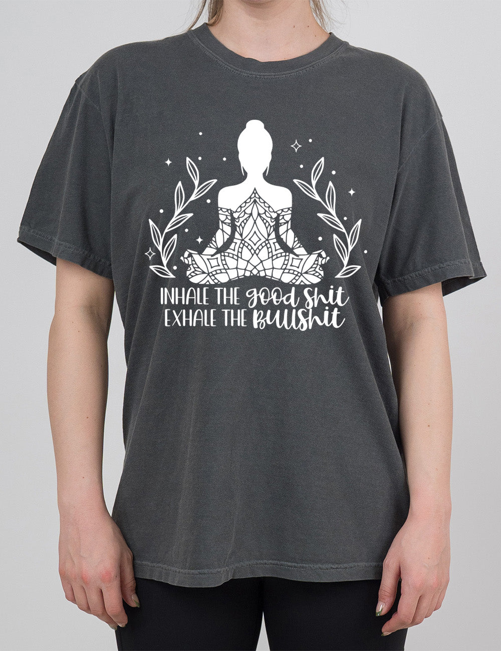 pepper modern tee with the graphic of a woman's silhouette (partially covered in elaborate shapes) with a plant on either side, surrounded by little stars, and the words underneath saying "Inhale the good shit exhale the bullshit"