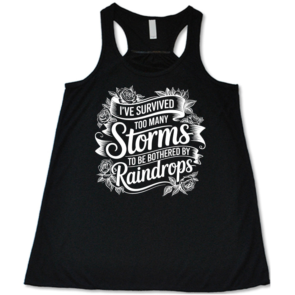 Black Flowy Tank, with wording I've Survived Too Many Storms to be Bothered by Raindrops, banners and flowers