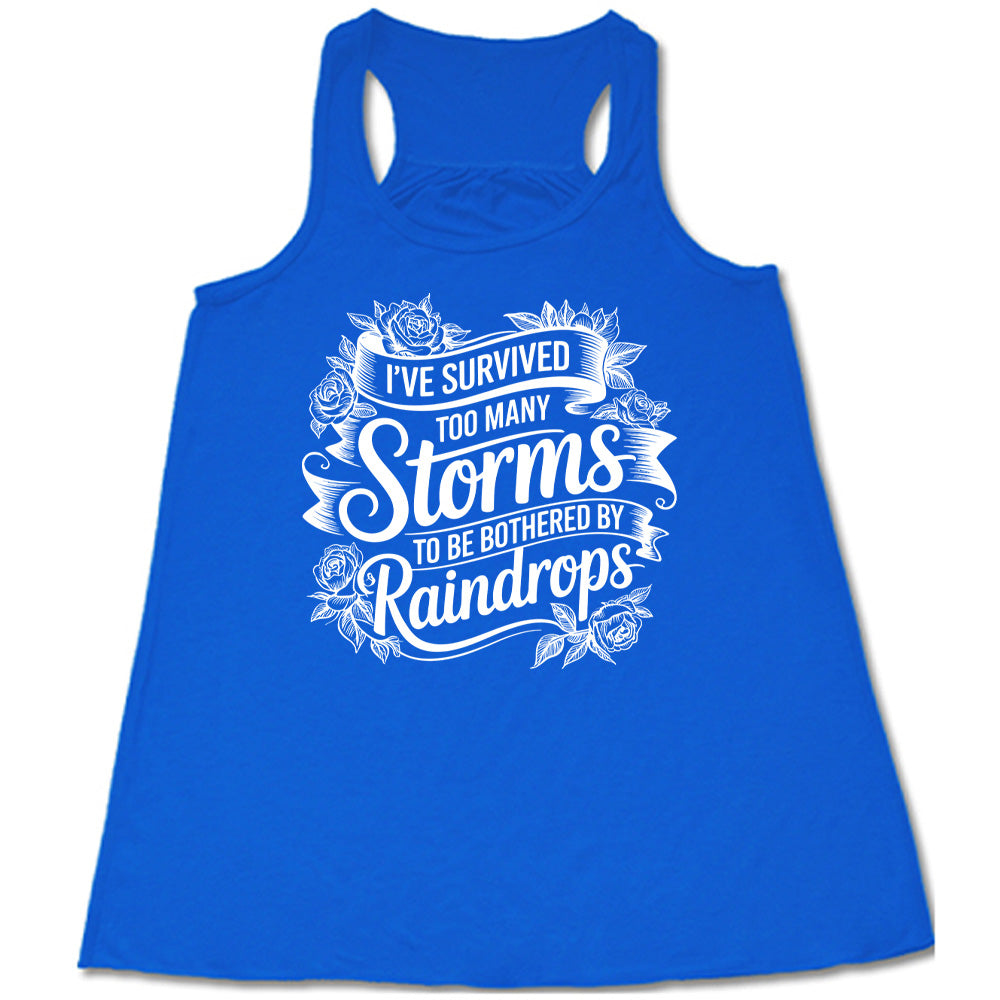 Blue Flowy Tank, with wording I've Survived Too Many Storms to be Bothered by Raindrops, banners and flowers